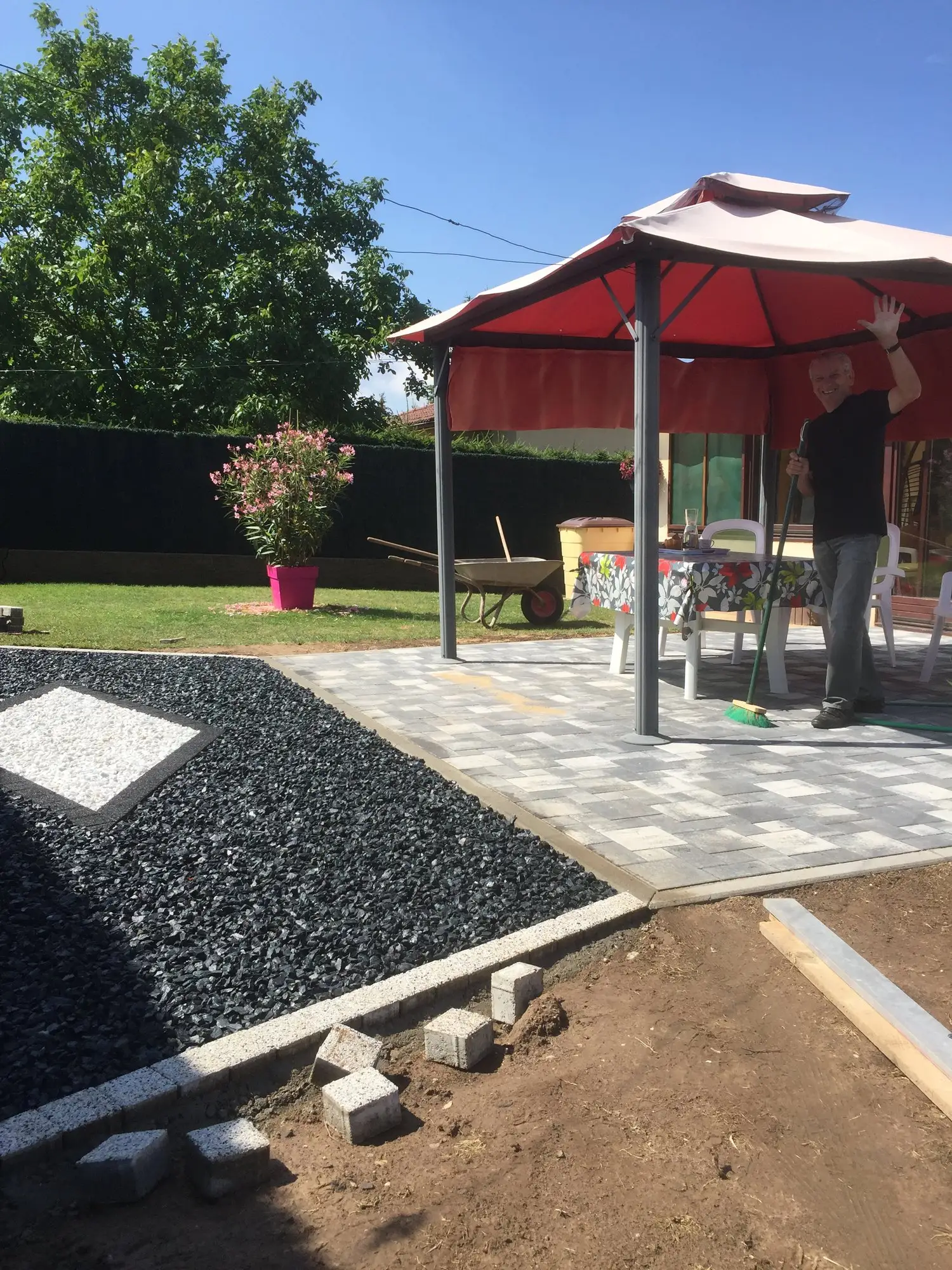 Jardin aménagé avec gravier noir décoratif, motif en losange et allée pavée