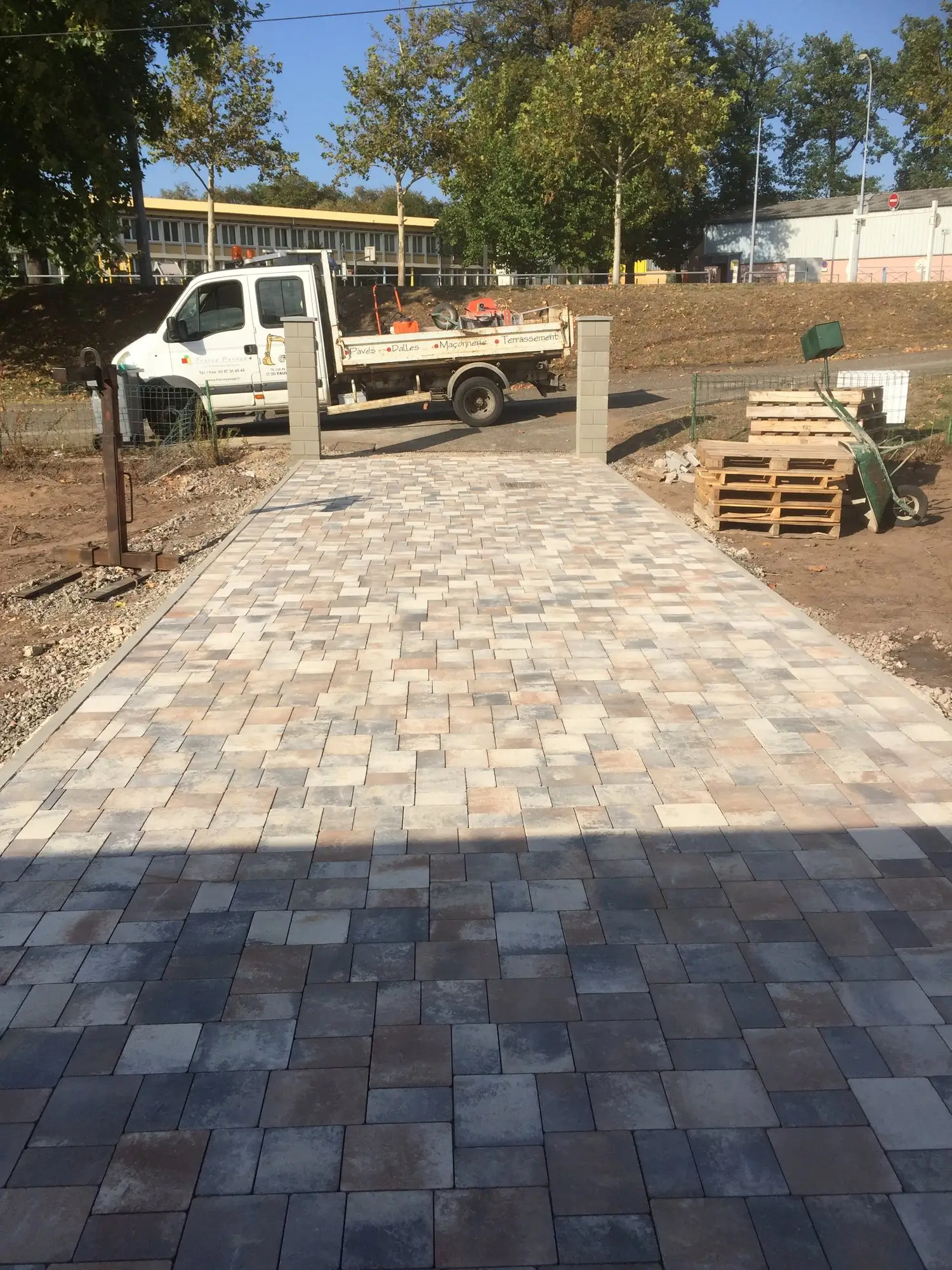 Pose de pavés en cours sur fondation compactée, chantier d’aménagement extérieur