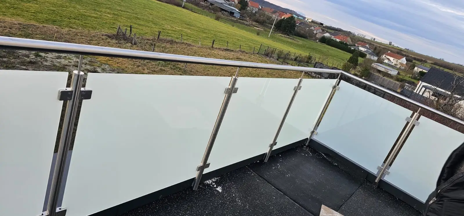 Garde-corps en verre feuilleté et poteaux inox sur une terrasse en hauteur
