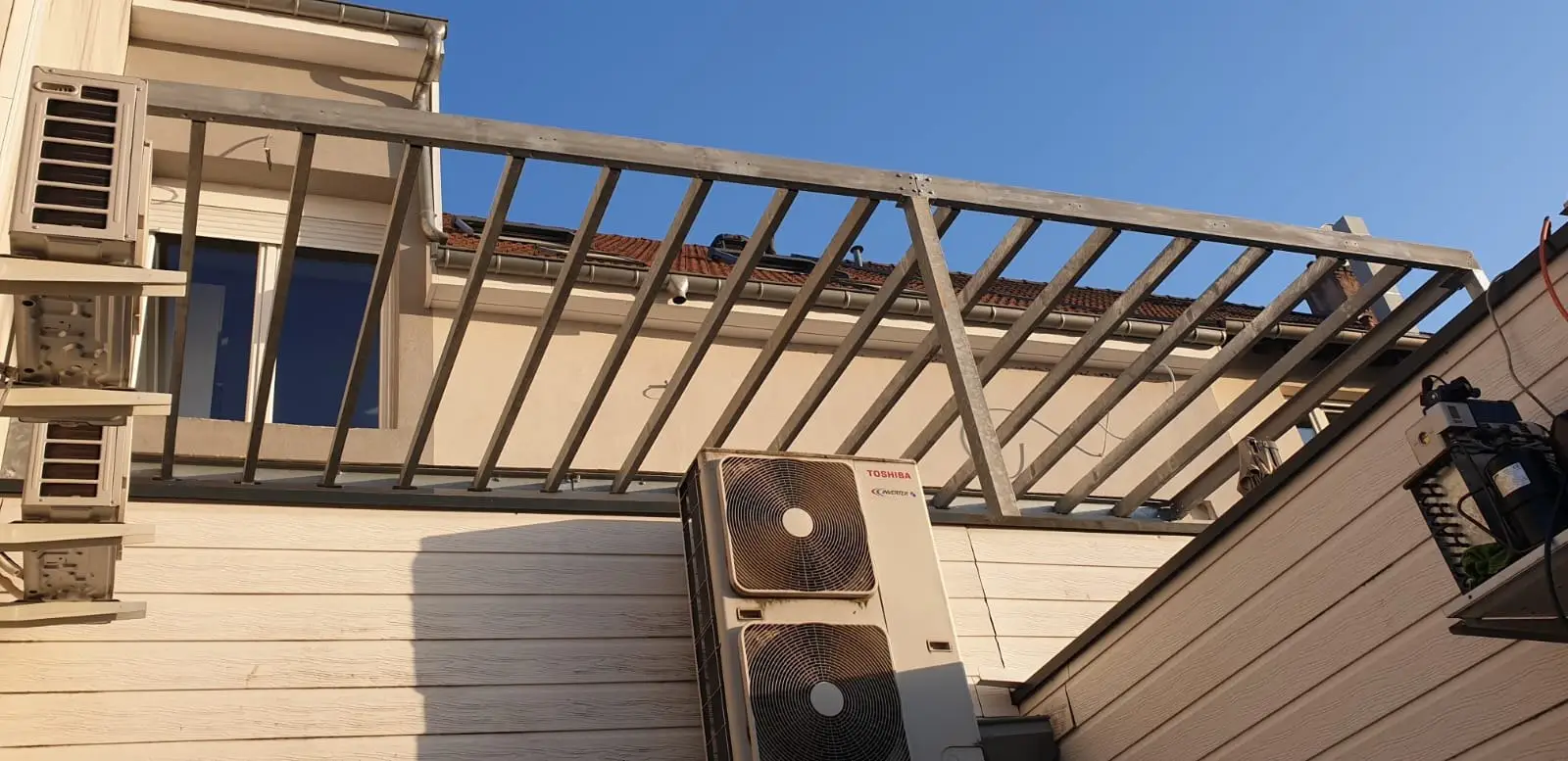 Terrasse surélevée sur structure métallique avec garde-corps à barreaux